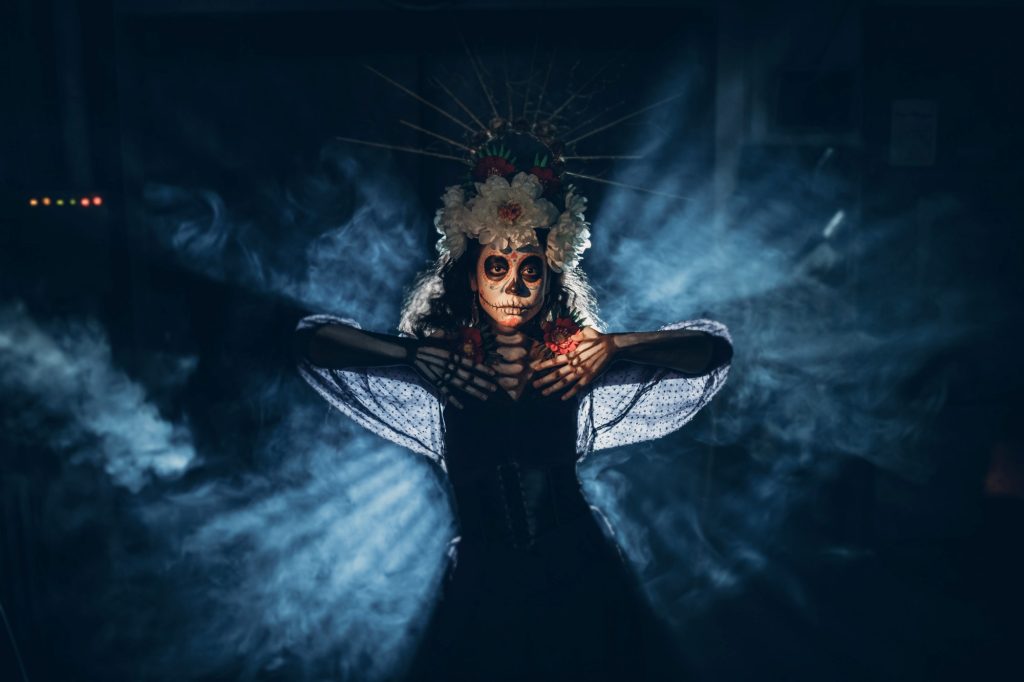 Woman with mexican skull halloween makeup in dark. Day of the dead Dia de los Muertos.